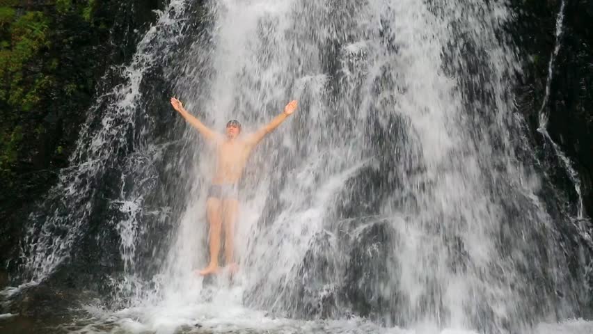 Handsome and muscular man bathing in a huge wild waterfall. Huay Toh Waterfall,