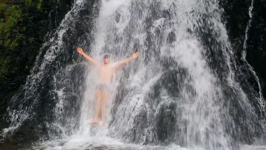 Handsome and muscular man bathing in a huge wild waterfall. Huay Toh Waterfall,