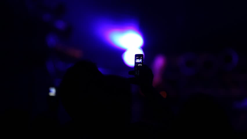 Man filming concert with his cell phone