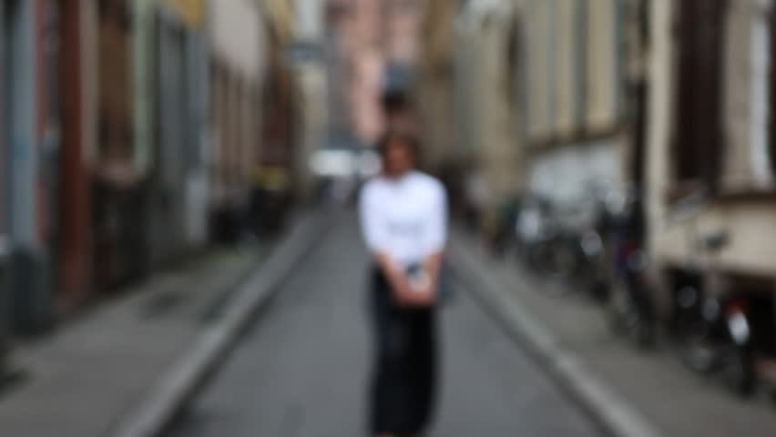 Business woman with laptop walking into focus