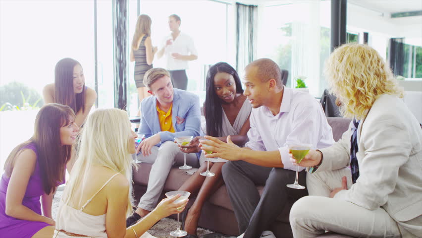 Glamorous group of friends chatting over cocktails, laughing and having a good time in luxury modern home | Shutterstock HD Video #5261369