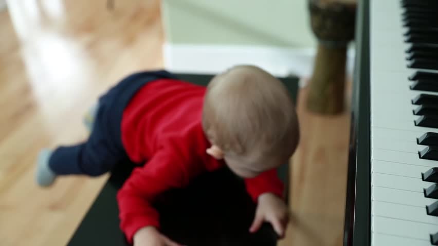 A child playing with an upright black piano bench