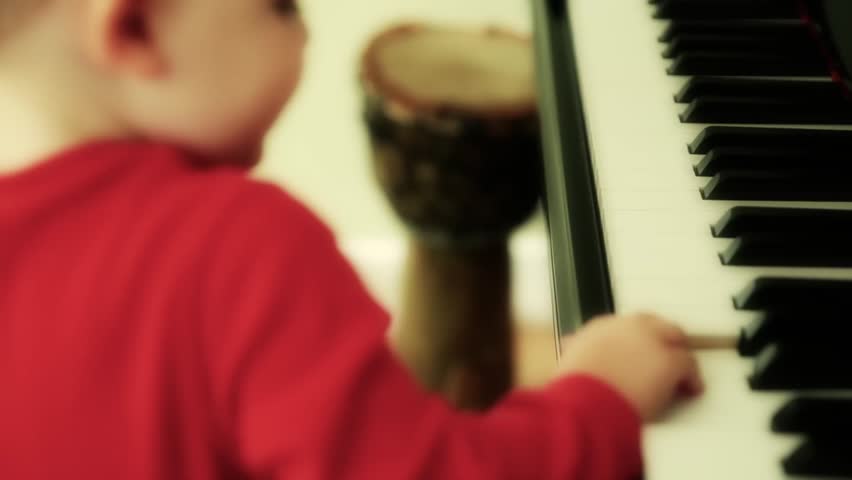 A child playing with an upright black piano