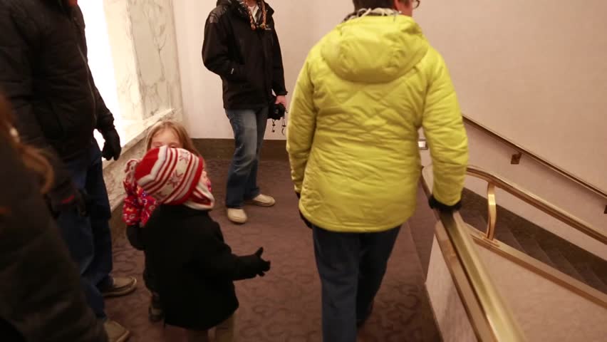 A family walks down the stairs of a public building