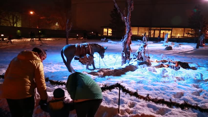 Families walking around the christmas lights and nativity at temple square in