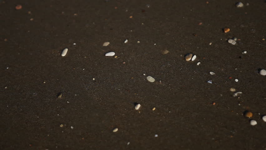 Gentle surf on beach with little stones
