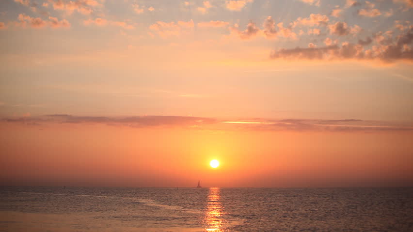 Mediterranean sunrise with sailing boat in the horizon