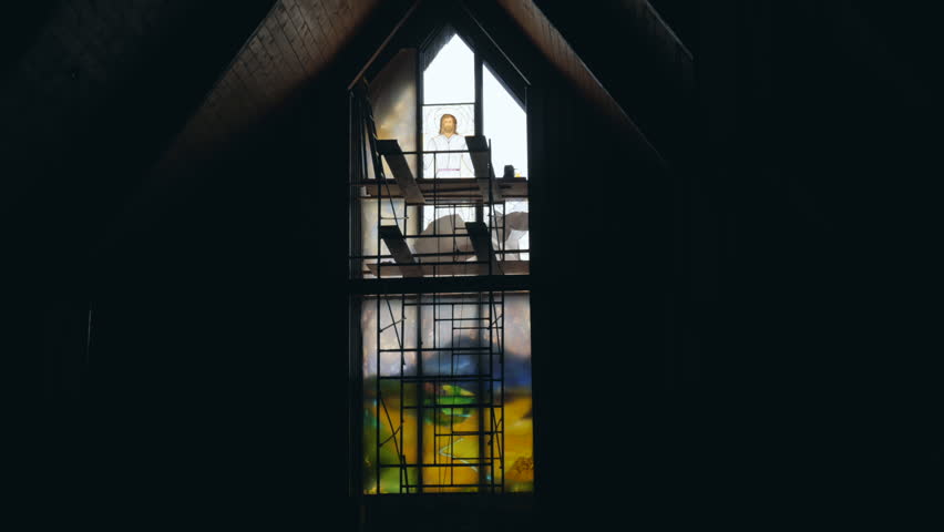 Time lapse of glass artist installing stained glass windows in a church