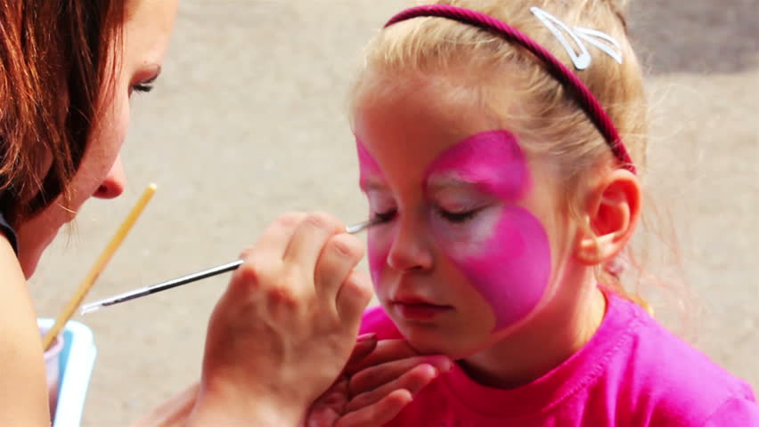 artist paints on face of little girl