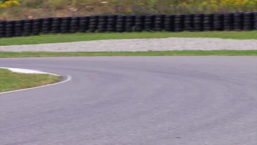 A black car turns a corner at Calabogie Raceway. 