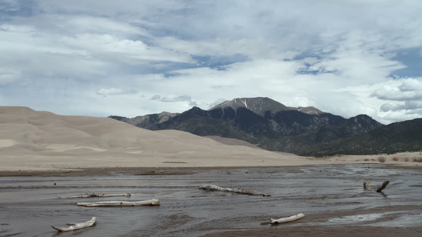 Clouds over the Great Sand Dunes, with Medano Creek in the foreground. HD 1080p