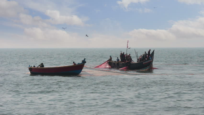 fishermen in boats pulling fishing nets - Kerala India