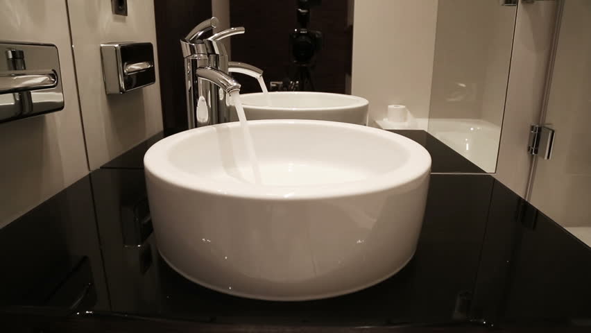 water flows from tap into modern sink