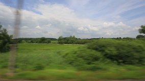 Side view from a passenger train of the countryside of Poland.