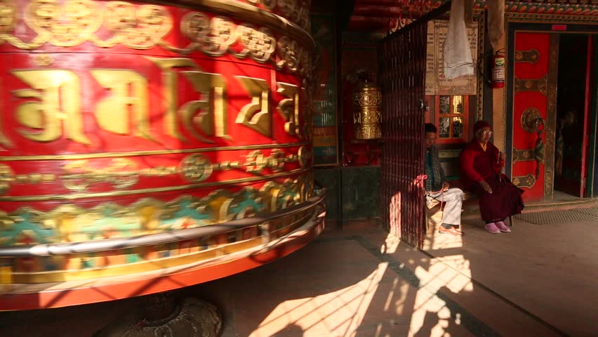 KATHMANDU, NEPAL - DEC 8: Unidentified pilgrim woman touches spinning Big