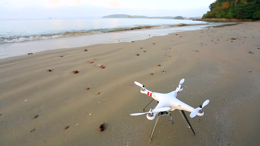 Quadcopter quadrocopter takes off from the deserted beach. Krabi, Thailand.
