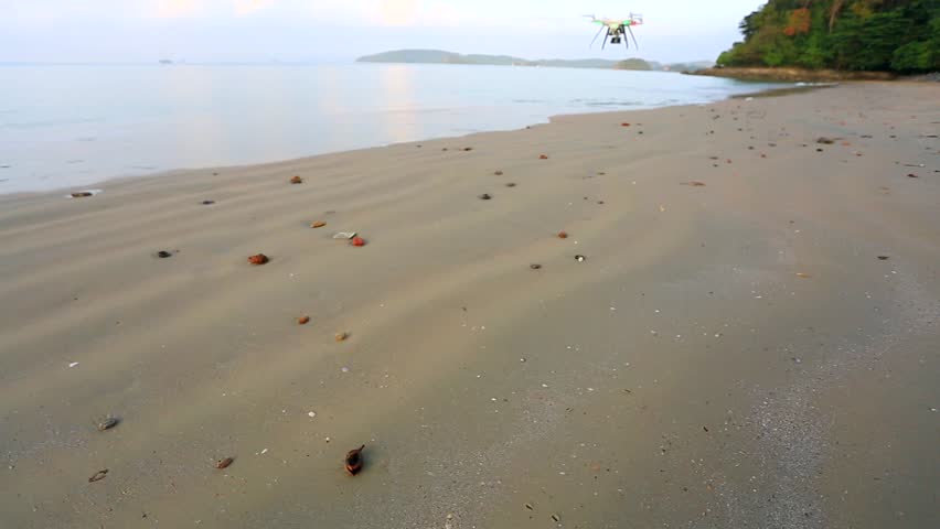 Quadcopter quadrocopter landing on a deserted beach. Krabi, Thailand.