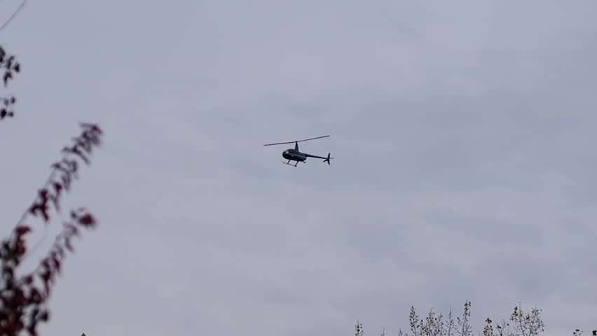 Blue helicopter flying at a very low level