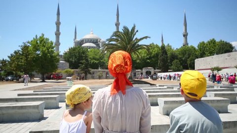 Back of family looking at beautiful Sultanahmet Mosque (Blue Mosque) near Hagia Sophia in Istanbul, Turkey