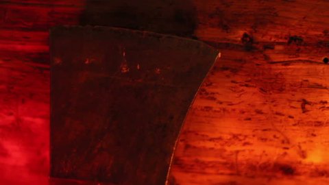 Side view of a sharp axe under a red-lighted room