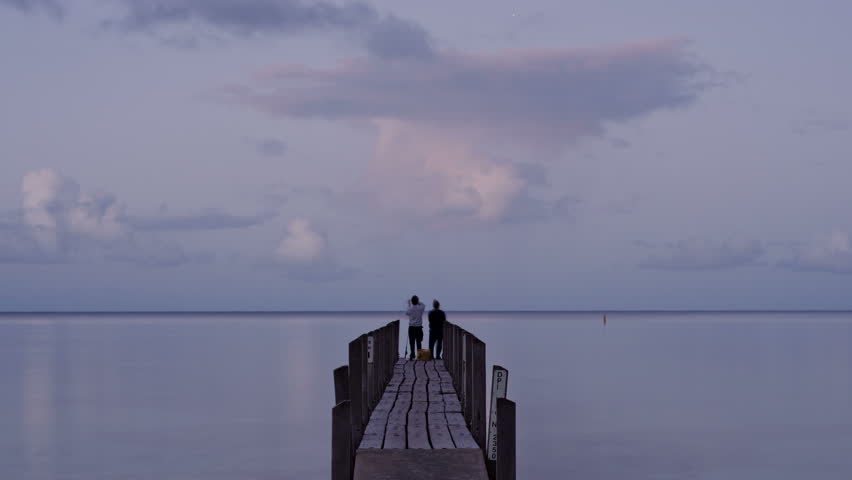Young couple fishing on the Quindalup jetty at sunset. Quindalup is near