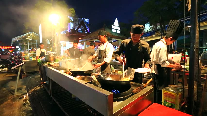 SIEM REAP, CAMBODIA - CIRCA DECEMBER: Pub Street, chef cook a meal at
