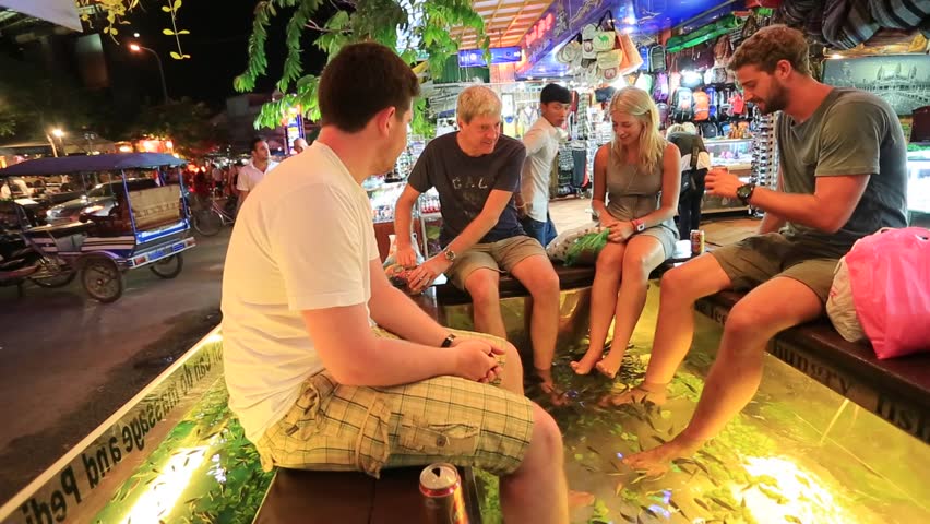 SIEM REAP, CAMBODIA - CIRCA DECEMBER: People enjoy fish foot massage at Pub