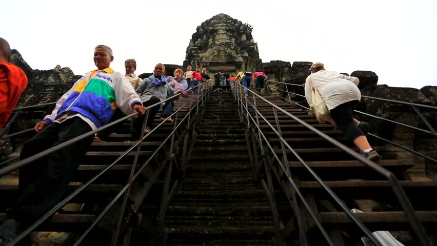 ANGKOR, CAMBODIA - CIRCA DECEMBER: tourists climbing steps of Angkor Wat, on