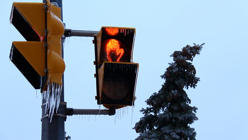 Icy Storm Crosswalk Sign Turns Green. Crosswalk light with icicles hanging from
