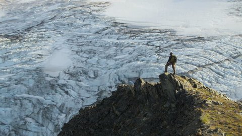 Aerial view of male mountain climber in summer enjoying success high Peaks Troublesome Glacier Chugach Mountains South Central Alaska, USA shot on RED EPIC, 4K, UHD, Ultra HD resolution