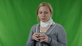 A young woman caught a cold, something hot drink from a cup - Flu and colds - Video footage to chroma-key background.