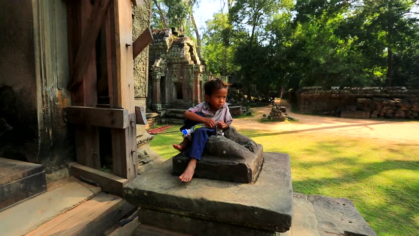 ANGKOR, CAMBODIA - CIRCA DECEMBER: Cambodian boy at Ta Prohm Temple, on circa