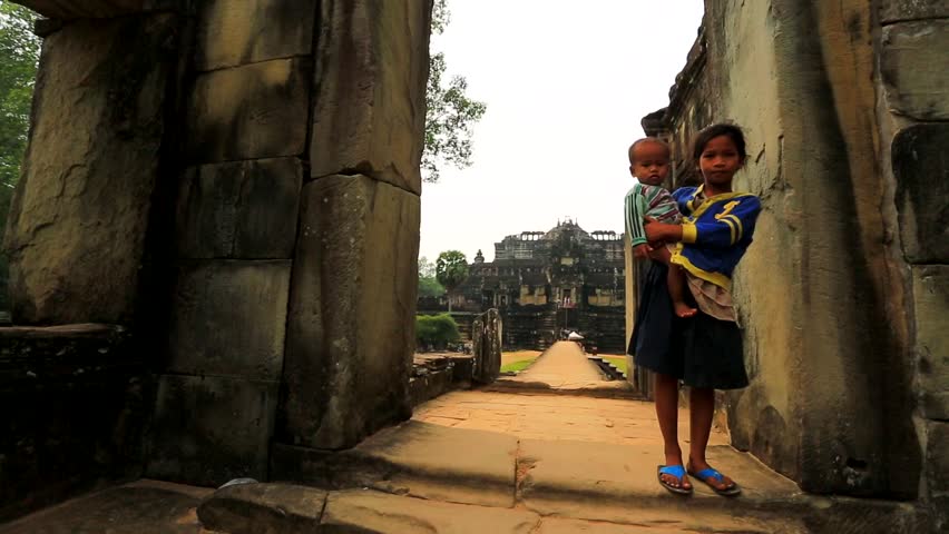 ANGKOR, CAMBODIA - CIRCA DECEMBER: Cambodian girl holding a baby at Baphuon