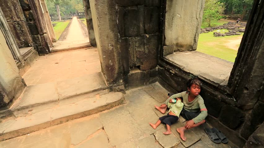 ANGKOR, CAMBODIA - CIRCA DECEMBER: Cambodian boy holding a baby at Baphuon