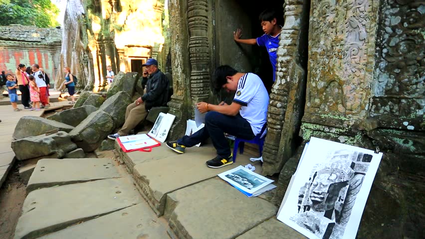 ANGKOR, CAMBODIA - CIRCA DECEMBER: Boy draws a picture at Ta Prohm Temple, on
