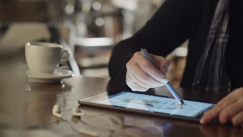 Woman Drawing on Tablet PC in Coffee Shop. Shot on RED Digital Cinema Camera in 4K (ultra-high definition (UHD)), so you can easily crop, rotate and zoom, without losing quality.