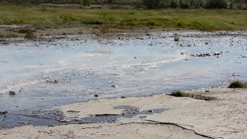 Small thermal stream running among grass and mud at Geysir area, Iceland