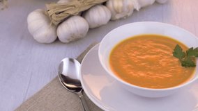 Pumpkin soup on white wood background.