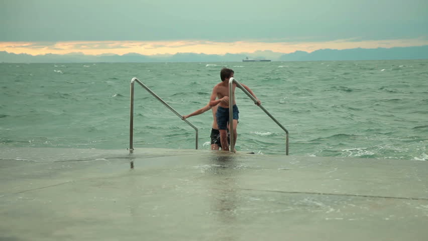 Kids come out of the sea and receive a huge splash