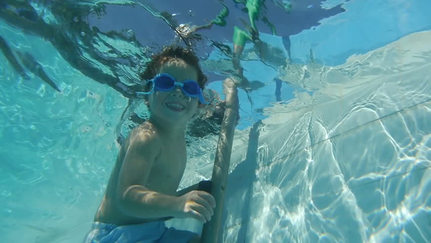 Boy diving and waving hand saying hello in swimming pool. Super Slow Motion.
For videos about: swimming, pools, summer fun, vacation, getaways, underwater footage, kids, beating the heat, and exercise