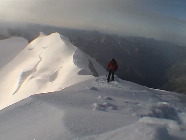 Mountaineer walking along a snowy ridge. Monte Castore, Monte Rosa, italian Alps, europe