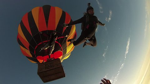 Skydiving couple jumping from hot air balloon in the morning
