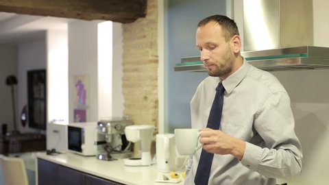 Young businessman drinking tea in the kitchen

