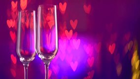 Valentine's Day Celebrating. Two Champagne Glass over Holiday Blinking Abstract Valentine Background with Hearts. HD Video Footage