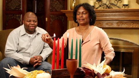 Couple light candles for Kwanzaa. 