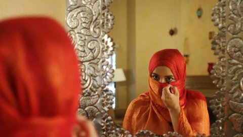 Arabic Woman In Orange Hajib Applies Eyeliner