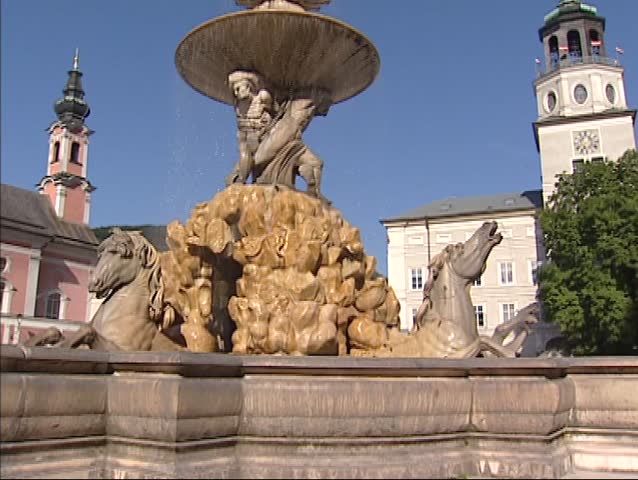 SALZBURG, AUSTRIA -  low angle + tilt up large baroque fountain at Residenzplatz in the historic city center. The Historic Center of the City of Salzburg UNESCO World Heritage Site.