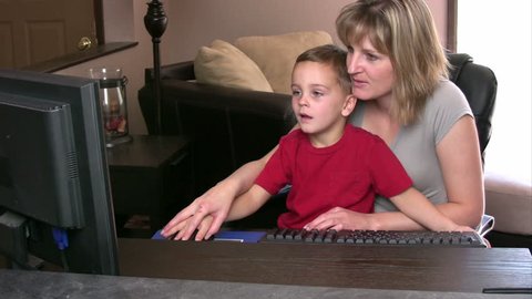 Mother and her son having fun on a computer