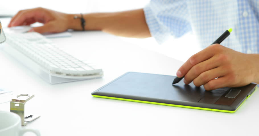 Focused businessman working on his computer and tablet in his office