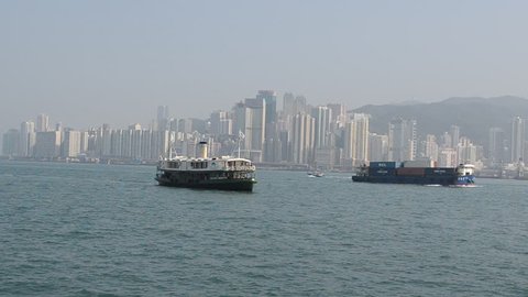 Cargo ships cruising victoria harbor in hong kong